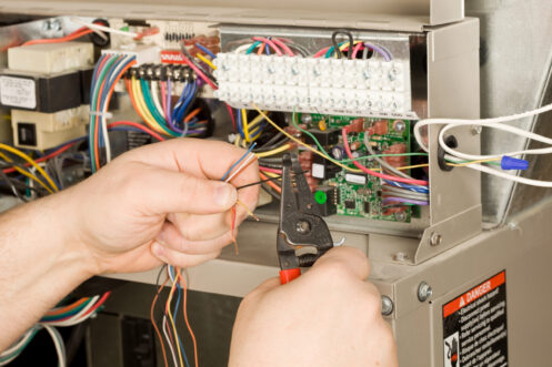 A technician repairing a furnace in O'Fallon, MO